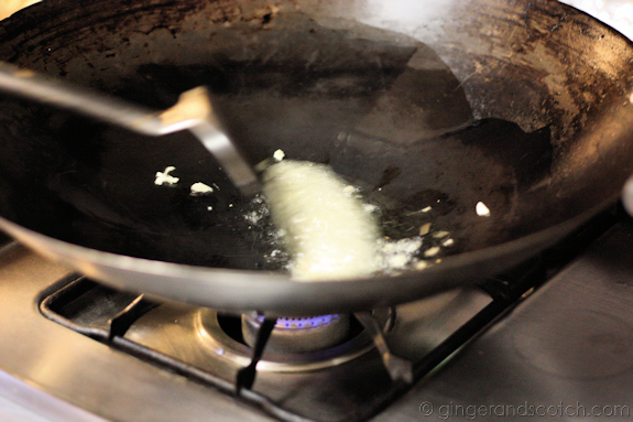 Clams in Asian Basil Sauce - Garlic and ginger being swished around in hot oil