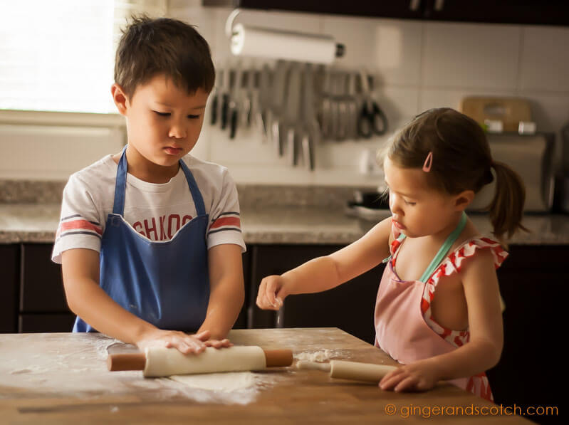 Kids rolling out dough for homemade Chinese noodles